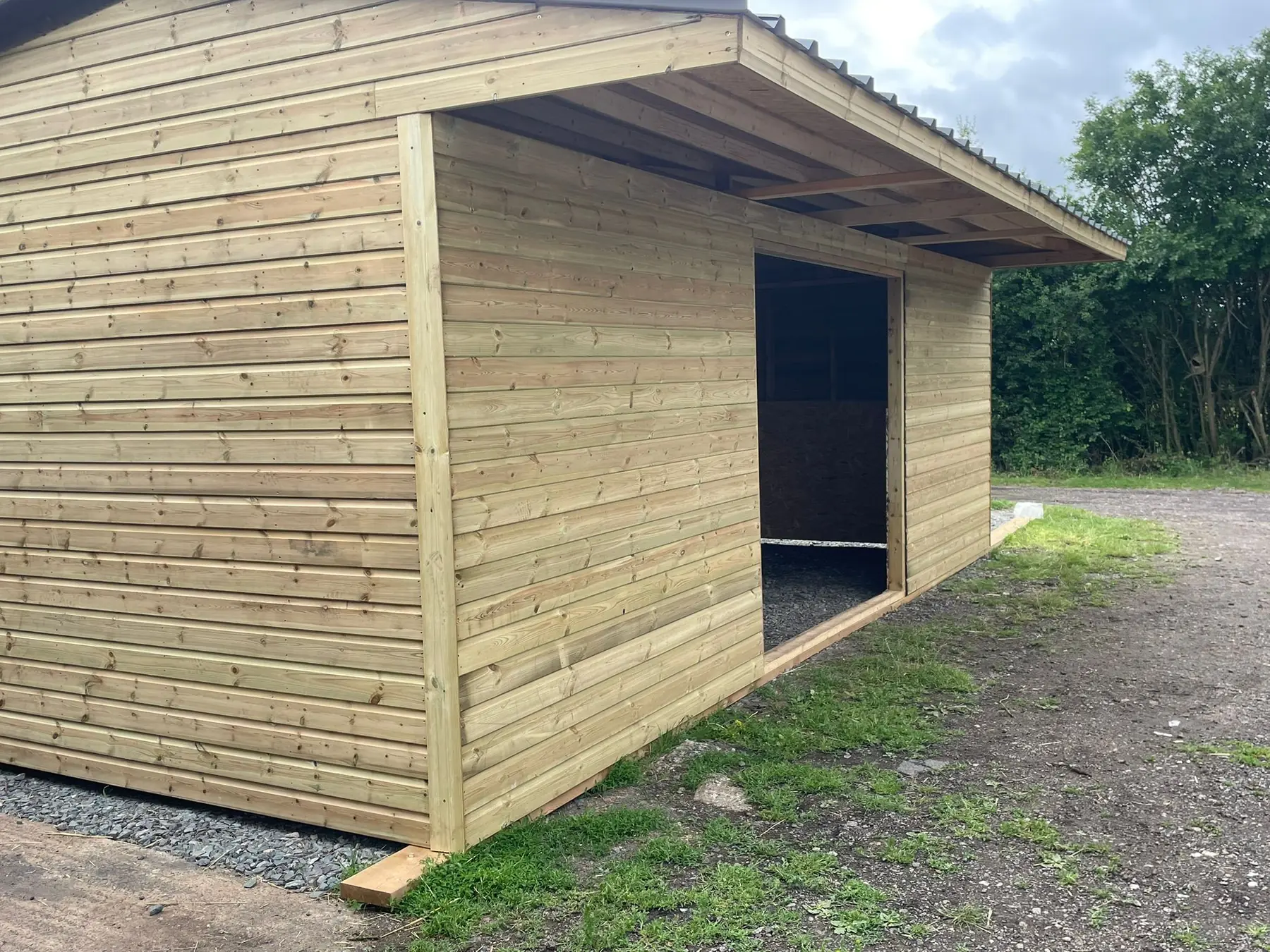 Angled view of a timber field shelter with an open front