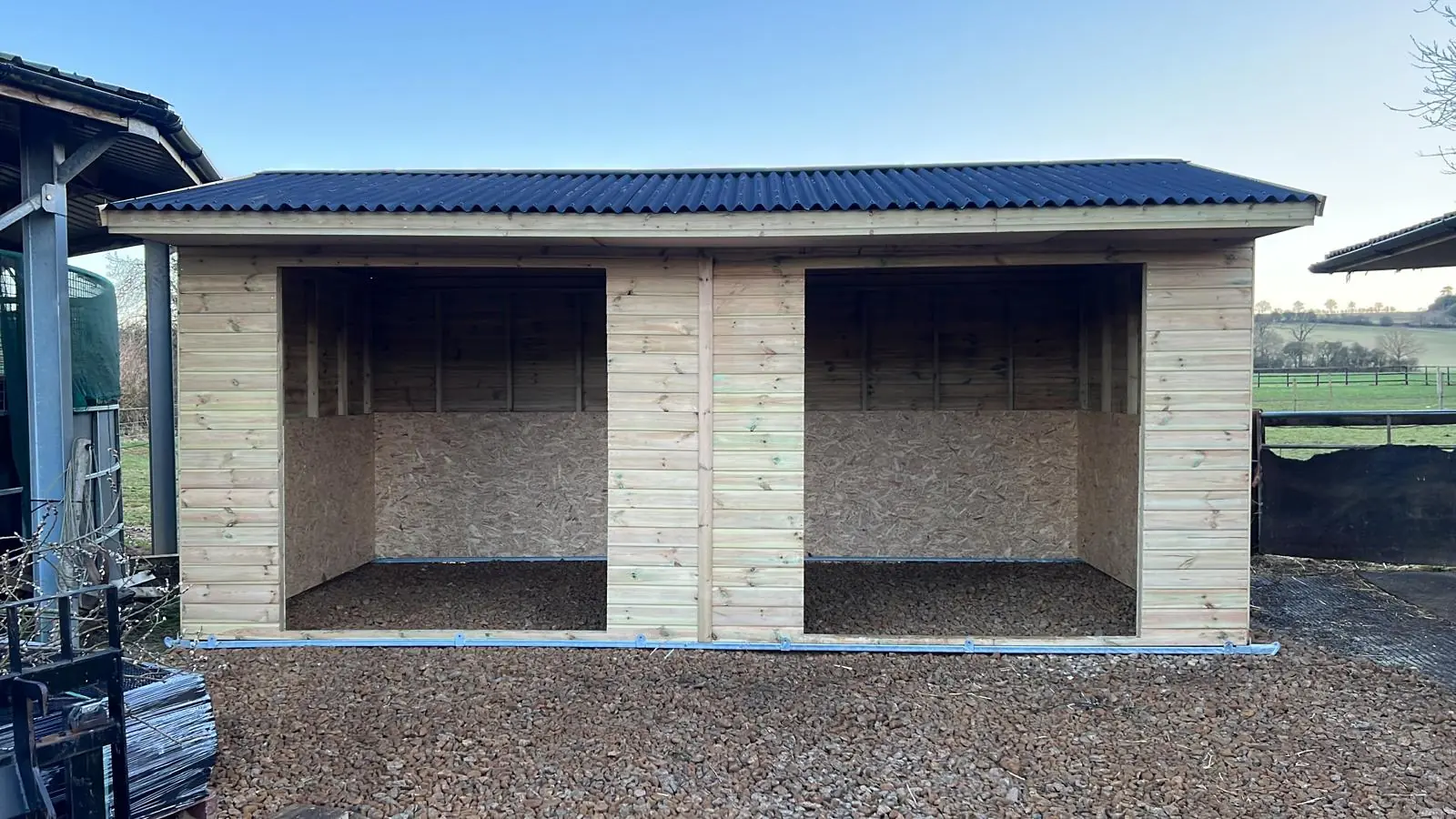 Timber field shelter with two open bays in a paddock