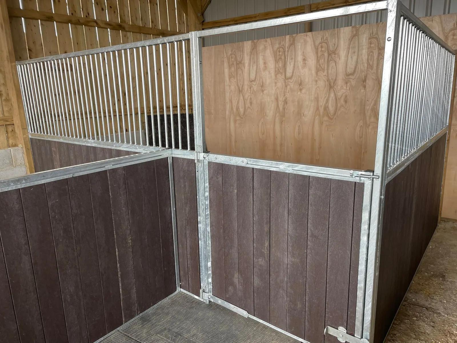 Close view of a stable divider with dark panels and vertical metal bars
